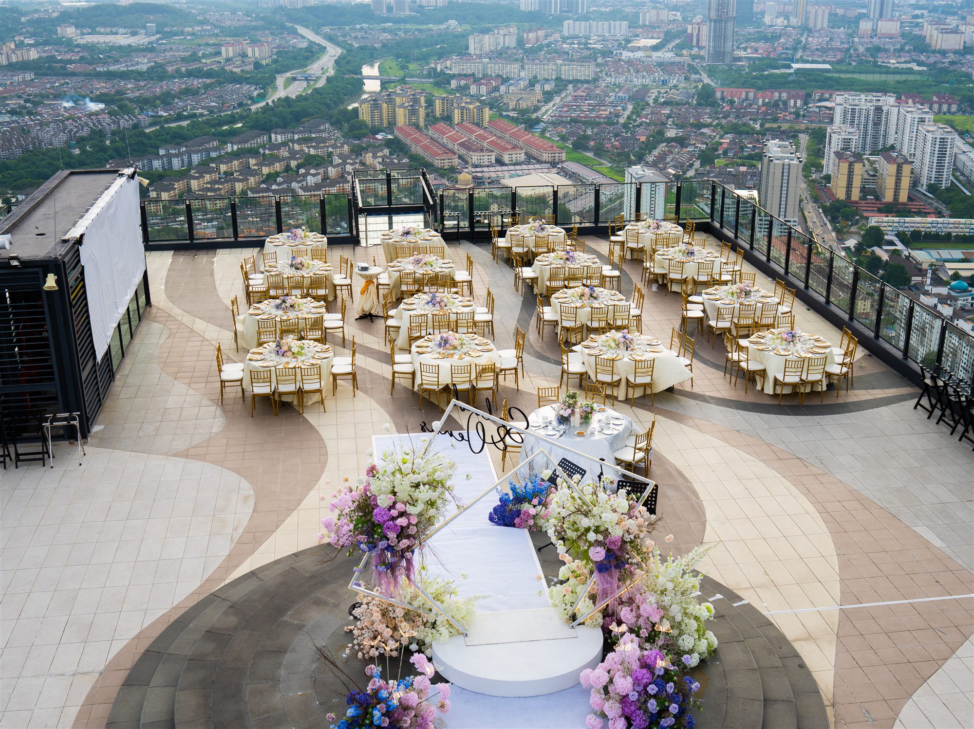 Bird's eye aerial view of full rooftop wedding reception setup with KL cityscape